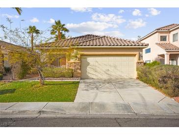 Charming single-story home with a two-car garage, tile roof, stone accents, and well-manicured lawn at 1184 Warm Canyon Way, Las Vegas, NV 89123