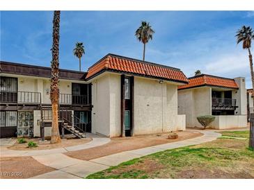 Multi-Gathering home with a red tile roof, palm trees, walkways and a green lawn on a sunny day at 1405 Vegas Valley Dr # 170, Las Vegas, NV 89169