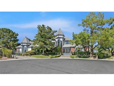 Stately home exterior featuring manicured landscaping, architectural details, and a circular driveway at 3111 Coachlight Cir, Las Vegas, NV 89117