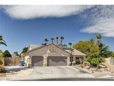 Charming single-story home featuring a three-car garage and desert landscaping with palm trees at 6513 Echo Crest Ave, Las Vegas, NV 89130