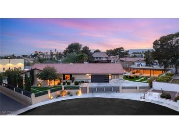 Expansive single-story home featuring a tile roof, manicured lawn, mature trees, and circular driveway at 6975 Darby Ave, Las Vegas, NV 89117