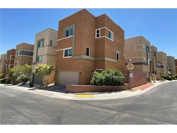 Modern three-story home showcasing a contemporary design, tidy landscaping, and an attached garage at 10537 Headwind Ave, Las Vegas, NV 89129