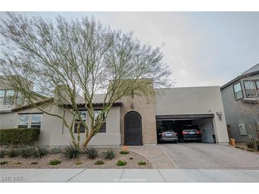 Charming single-story home featuring a brick driveway, arched doorway, and a convenient two-car garage at 1608 Rock Ridge Pl, North Las Vegas, NV 89084