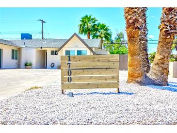 Charming home featuring desert landscaping, palm trees, and a wooden address marker out front at 1700 Ivanhoe Way, Las Vegas, NV 89102