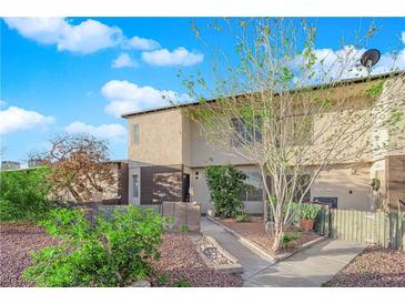 Charming two-story townhome with well-maintained landscaping and inviting curb appeal under a bright, partly cloudy sky at 241 E Van Wagenen St, Henderson, NV 89015