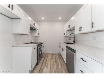 Updated kitchen featuring white cabinets, stainless steel appliances, and modern countertops at 2915 Cedar Ave # 12C, Las Vegas, NV 89101