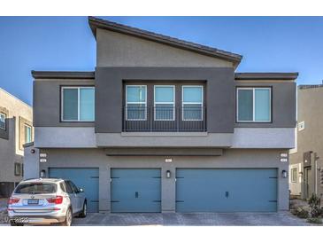 Modern two-story home showcasing a gray exterior, three-car garage, and a small balcony with iron railing at 4278 Lemay St # 2, Las Vegas, NV 89115