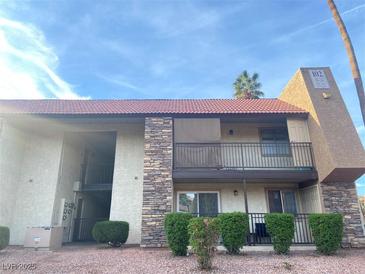 Inviting condo complex featuring stone accents, a red tile roof and well-maintained landscaping at 4370 Sandy River Dr # 24, Las Vegas, NV 89103