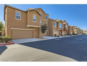 Charming street view of modern townhomes featuring attached garages and well-maintained landscaping at 5179 Silica Chalk Ave, Las Vegas, NV 89115