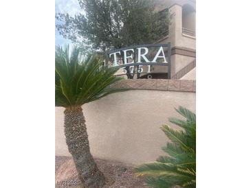 The Tera community signage with desert landscaping against a neutral color scheme adds welcoming curb appeal at 5751 E Hacienda Ave # 159, Las Vegas, NV 89122