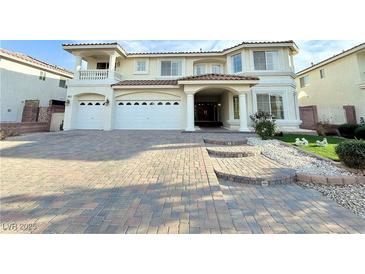 Elegant two-story home featuring a three-car garage and a spacious driveway with professional landscaping at 6625 Gossamer Fog Ave, Las Vegas, NV 89139