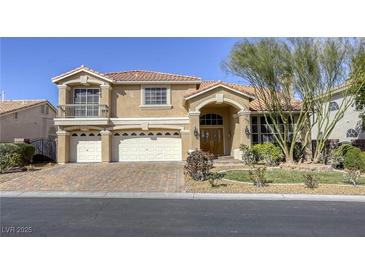 Charming two-story home with a three-car garage, terracotta roof, manicured landscaping, and a paver driveway at 7641 Jacaranda Bay St, Las Vegas, NV 89139