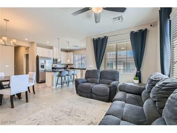 Open-concept living room features neutral tones, a ceiling fan, and lots of natural light at 8490 Classique Ave # 101, Las Vegas, NV 89178