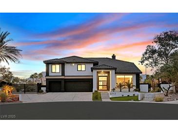 Stunning two-story home featuring a modern design, manicured landscaping, and a three-car garage at 8717 Kingship Ct, Las Vegas, NV 89129