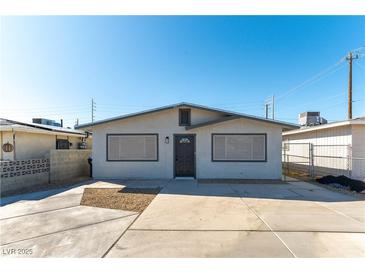 Charming single story home featuring a modern exterior and well maintained landscaping with a large driveway at 887 W Carey Ave, North Las Vegas, NV 89030