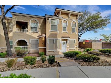 Inviting townhome with manicured landscaping, arched entry, and stylish architectural details at 10001 Peace Way # 1321, Las Vegas, NV 89147