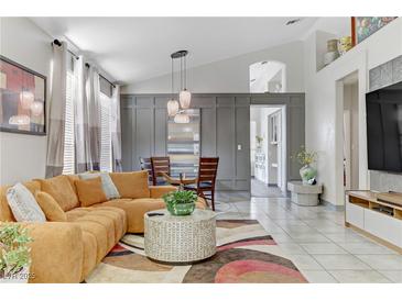 Bright living room featuring a comfortable sectional couch, modern lighting, and stylish decor at 139 Serenade Ct, Henderson, NV 89074