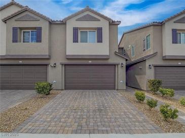 Charming townhome with brown shutters, a two-car garage, and a paved driveway with desert landscaping at 3795 Canis Minor Ln # 5102, Henderson, NV 89052