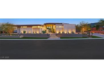 Striking modern home with manicured landscaping, illuminated stairs and attractive exterior lighting features at 49 Crested Cloud Way, Las Vegas, NV 89135