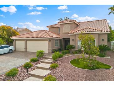 Beautiful two-story home featuring lush landscaping, a tile roof, and a two-car garage at 5205 Sandy Cactus Ln, Las Vegas, NV 89149