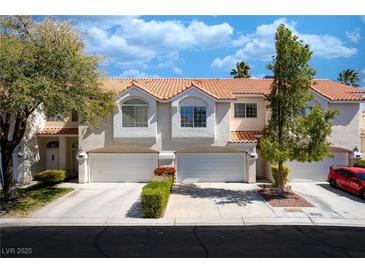Charming townhome featuring a two-car garage, red-tile roof and manicured landscaping at 5256 Harvest Breeze Rd, Las Vegas, NV 89118