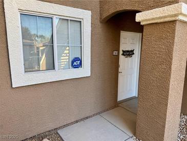 Inviting front entrance with textured wall, security system, and white front door at 833 Aspen Peak Loop # 2613, Henderson, NV 89011