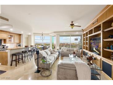 Spacious living room with large windows, comfortable seating, and built in shelves and entertainment center at 9101 Alta Dr # 307, Las Vegas, NV 89145