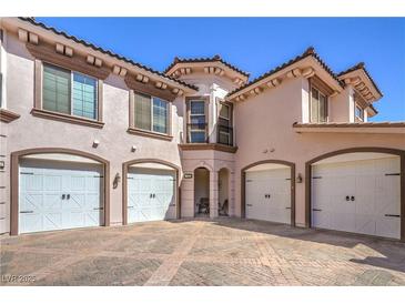 Charming townhome with four garages, desert landscaping, and a brick paved driveway at 10 Via Visione # 103, Henderson, NV 89011