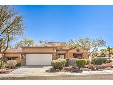 Charming single-story home with a neutral color scheme, tile roof, manicured landscaping, and an attached two-car garage at 10057 Bundella Dr, Las Vegas, NV 89134