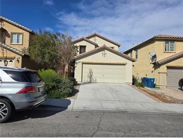 Two-story home featuring a two-car garage, neutral stucco and desert landscaping in a residential neighborhood at 11763 Village Arbor St, Las Vegas, NV 89183