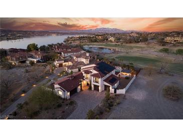 Breathtaking aerial view of a luxurious home with a red tile roof, pool, and stunning sunset views at 18 Grand Corniche Dr, Henderson, NV 89011