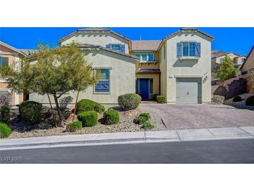 Charming two-story home featuring desert landscaping, a brick driveway, and blue shutters at 352 Sidewheeler St, Henderson, NV 89012