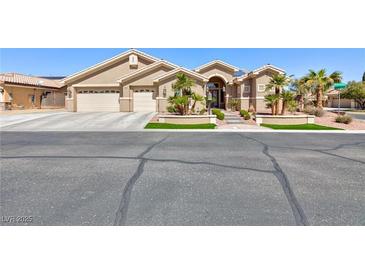 Beige single-story home with three-car garage and desert landscaping, offering curb appeal at 3662 Riley Ann Ave, Las Vegas, NV 89139