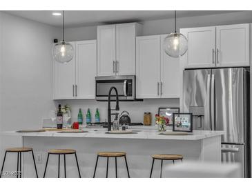 Modern kitchen featuring white cabinets, stainless steel appliances, and pendant lighting at 600 N Carriage Hill Dr # 1164, Las Vegas, NV 89138