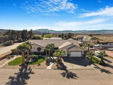 Charming home featuring a well-manicured front yard with palm trees and beautiful mountain views at 78 Siddall Ave, Las Vegas, NV 89183