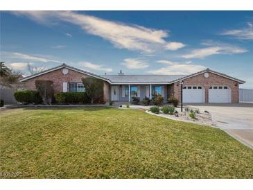 Charming single story home featuring a well-manicured lawn and an attached two car garage at 904 Hibiscus Ct, Henderson, NV 89011
