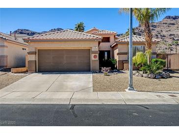 Charming single-story home featuring a desert landscape, tile roof and a two-car garage at 97 Zimmerman St, Henderson, NV 89002