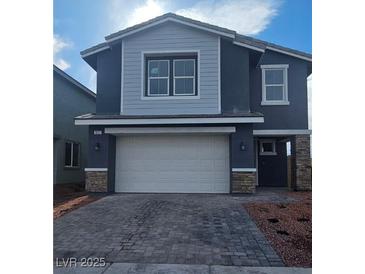 Two-story home featuring a two-car garage, stone accents, and low-maintenance landscaping at 1027 Gentle Swan St # 689, Henderson, NV 89011