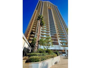 Stunning high-rise exterior showcasing modern architecture and lush landscaping with palm trees at 125 E Harmon Ave # 1003, Las Vegas, NV 89109