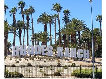 Picturesque view of the 'Rhodes Ranch' sign surrounded by tall palm trees and desert landscaping at 172 Tall Ruff Dr, Las Vegas, NV 89148