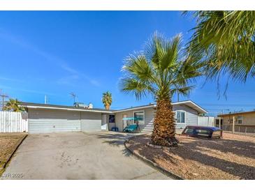 Charming single story home featuring a xeriscaped front yard and a long driveway leading to an attached garage at 2450 Tournament St, Las Vegas, NV 89142