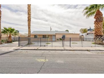 Charming single-story home featuring palm trees and a wrought iron fence at 4213 Hayes Pl, Las Vegas, NV 89107