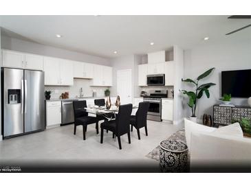 Modern kitchen featuring stainless steel appliances, white cabinets, and an adjacent dining area at 474 Ylang Pl # Lot 7, Henderson, NV 89015