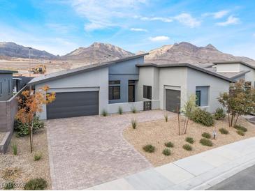 Stunning modern home featuring desert landscaping, a brick driveway, and mountain views at 477 Highview Ridge Ave, Las Vegas, NV 89138