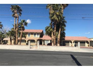 A beautiful exterior view of a home featuring multiple palm trees and a terra cotta tile roof at 6130 Tara Ave, Las Vegas, NV 89146