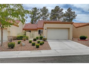 Exterior of single-Gathering home with a two car garage, a manicured lawn and desert landscaping at 8657 Prairie Hill Dr, Las Vegas, NV 89134