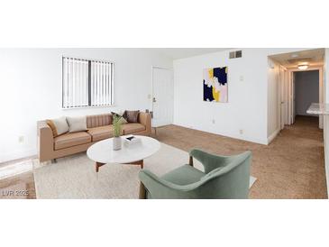 Bright living room featuring neutral walls, plush carpet, modern furniture, and a large window at 1212 Bass Dr # C, Henderson, NV 89014
