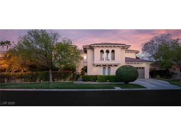 Inviting two-story home with a well-manicured lawn, mature trees, and tile roof at dusk at 1212 Muscato Ct, Las Vegas, NV 89144