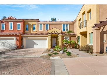 Charming two-story townhome featuring a well-maintained front yard and attached two-car garage at 23 Cerchio Basso, Henderson, NV 89011