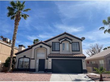 Charming two-story home featuring desert landscaping, a black garage door, and palm tree at 9139 Scallop Reef Ave, Las Vegas, NV 89147